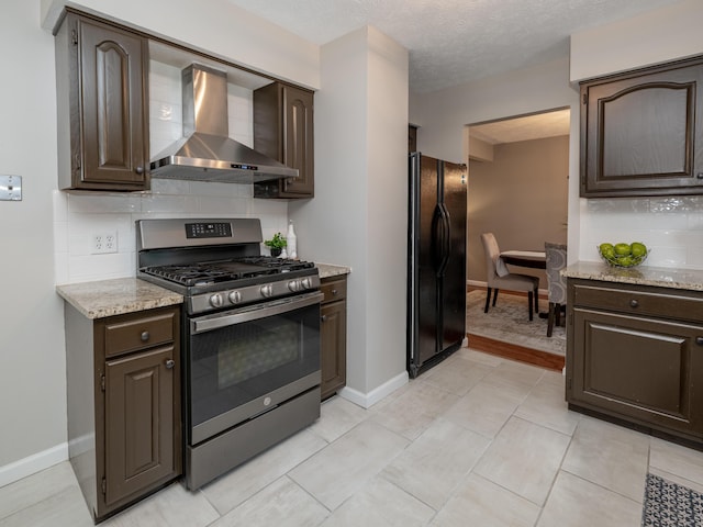 1627 Whitby Ave, Portage, MI 49024 - kitchen with stainless steel gas range, freestanding refrigerator, wall chimney range hood, dark brown cabinetry, and backsplash