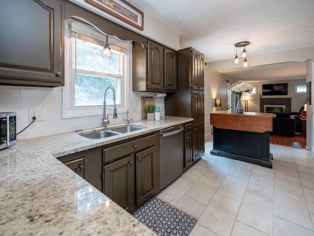 1627 Whitby Ave, Portage, MI 49024 - kitchen with dishwasher, a brick fireplace, tasteful backsplash, decorative light fixtures, and open floor plan