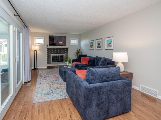 1627 Whitby Ave, Portage, MI 49024 - living area with light wood finished floors, a textured ceiling, and a brick fireplace