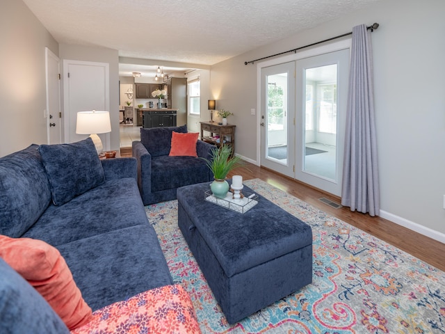 1627 Whitby Ave, Portage, MI 49024 - living area with wood finished floors, a chandelier, and a textured ceiling