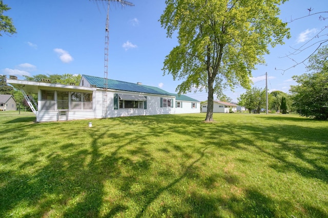 8020 Greenes Dr, Jackson, MI 49201 - rear view of property featuring a lawn, a sunroom, and a metal roof