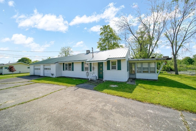 8020 Greenes Dr, Jackson, MI 49201 - ranch-style house with a front lawn, a sunroom, a metal roof, and driveway