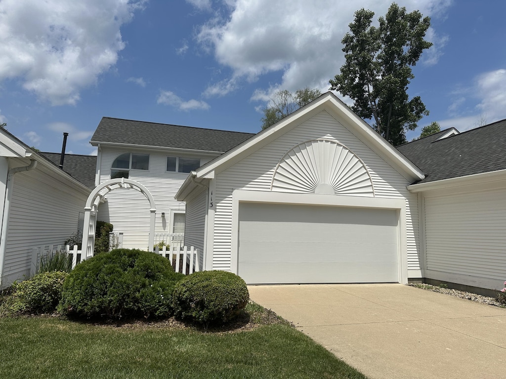 113 Quiet Creek Cir Unit 7, Chelsea, MI 48118 - view of front facade featuring an attached garage, concrete driveway, and roof with shingles
