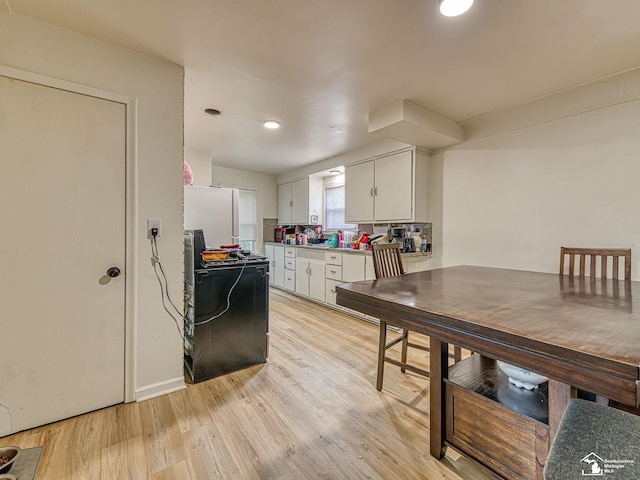 926 E Front St, Monroe, MI 48161 - kitchen with freestanding refrigerator, light wood-style flooring, white cabinetry, and recessed lighting