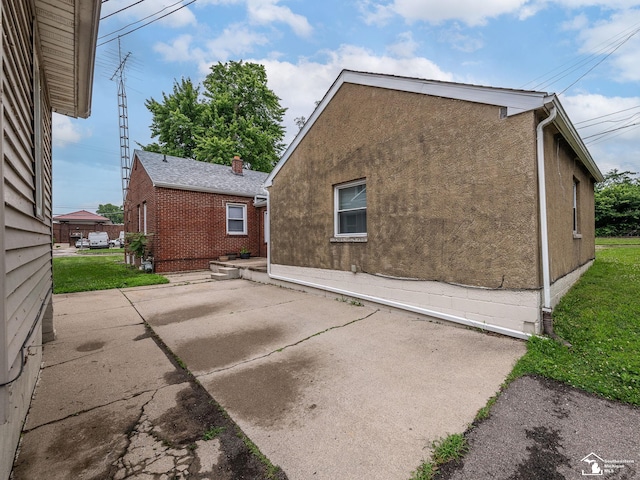 926 E Front St, Monroe, MI 48161 - back of property featuring a patio area, stucco siding, and a lawn