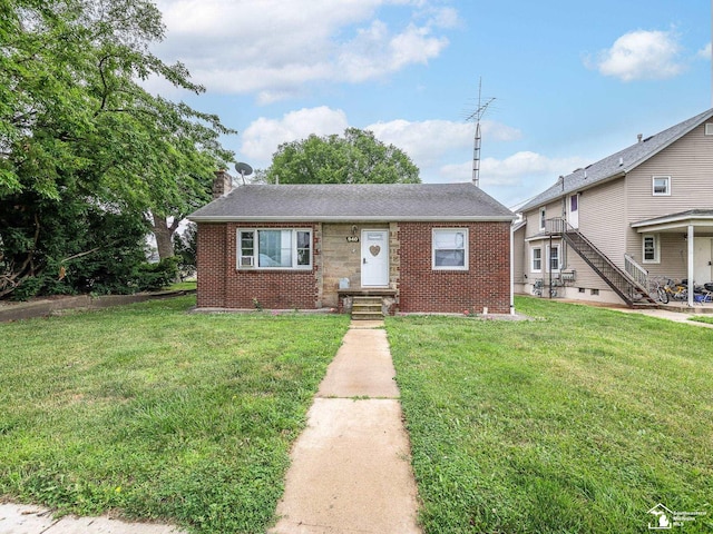 926 E Front St, Monroe, MI 48161 - bungalow-style house with brick siding, a front lawn, and a chimney