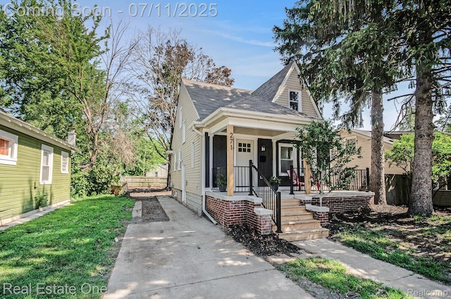 271 College St, Southfield, MI 48220 - view of front of property featuring covered porch, roof with shingles, and a front yard