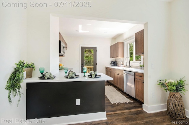 271 College St, Southfield, MI 48220 - kitchen featuring appliances with stainless steel finishes, dark wood-style flooring, brown cabinets, light countertops, and decorative backsplash