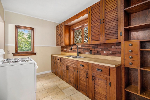 838 Lakeway Ave, Kalamazoo, MI 49001 - kitchen with white range with gas cooktop, brown cabinets, light countertops, crown molding, and light tile patterned floors