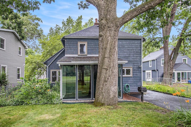 838 Lakeway Ave, Kalamazoo, MI 49001 - rear view of house featuring roof with shingles, a sunroom, a chimney, and a patio
