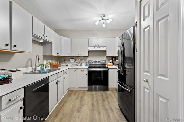 22145 W Village Dr, Dearborn, MI 48124 - kitchen with black appliances, light wood-type flooring, under cabinet range hood, and light countertops