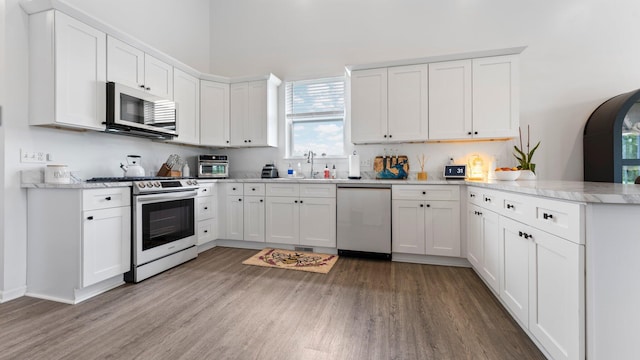 3850 Diuble Rd, Ann Arbor, MI 48103 - kitchen with stainless steel appliances, a peninsula, light wood-style flooring, and white cabinets