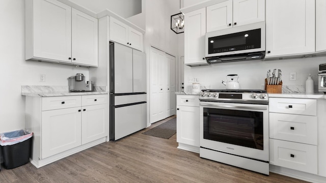 3850 Diuble Rd, Ann Arbor, MI 48103 - kitchen with white appliances, white cabinets, and light wood-style flooring