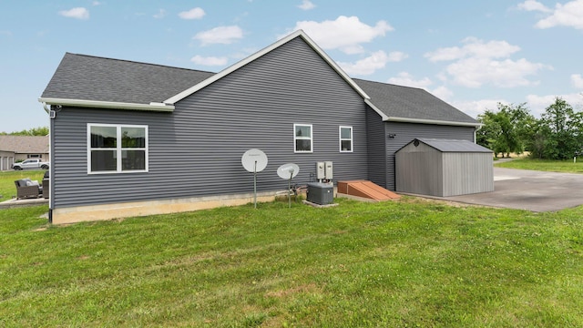 3850 Diuble Rd, Ann Arbor, MI 48103 - view of side of property featuring roof with shingles, a storage unit, and a yard