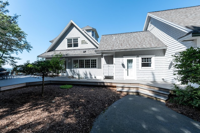 4569 N Ridge Rd, Mears, MI 49436 - view of front of house with a shingled roof, covered porch, and a wooden deck