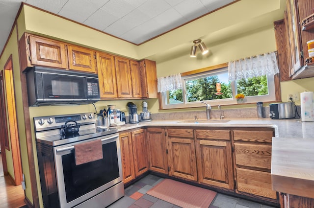 3914 135th Ave, Hersey, MI 49639 - kitchen featuring stainless steel range with electric cooktop, black microwave, light countertops, brown cabinetry, and crown molding