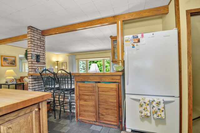 3914 135th Ave, Hersey, MI 49639 - kitchen with freestanding refrigerator, butcher block countertops, beam ceiling, and glass insert cabinets
