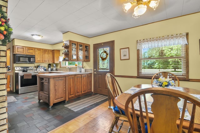 3914 135th Ave, Hersey, MI 49639 - kitchen featuring electric stove, black microwave, light countertops, brown cabinetry, and a peninsula