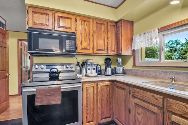 3914 135th Ave, Hersey, MI 49639 - kitchen with black microwave, stainless steel range with electric stovetop, light countertops, brown cabinetry, and wood finished floors