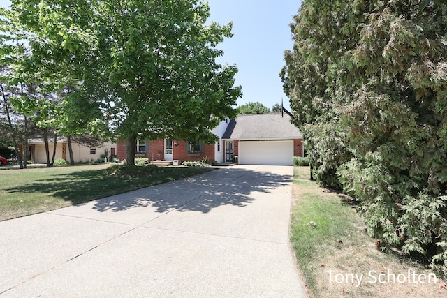 8179 Mellowwood Dr, Jenison, MI 49428 - obstructed view of property featuring brick siding, an attached garage, concrete driveway, and a front yard