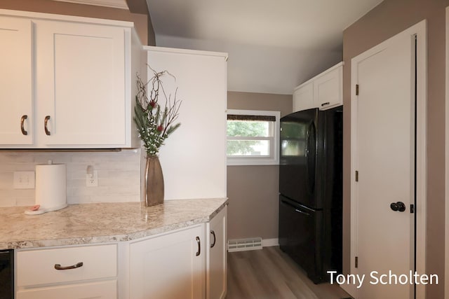 8179 Mellowwood Dr, Jenison, MI 49428 - kitchen featuring freestanding refrigerator, light countertops, white cabinets, backsplash, and dark wood-style floors