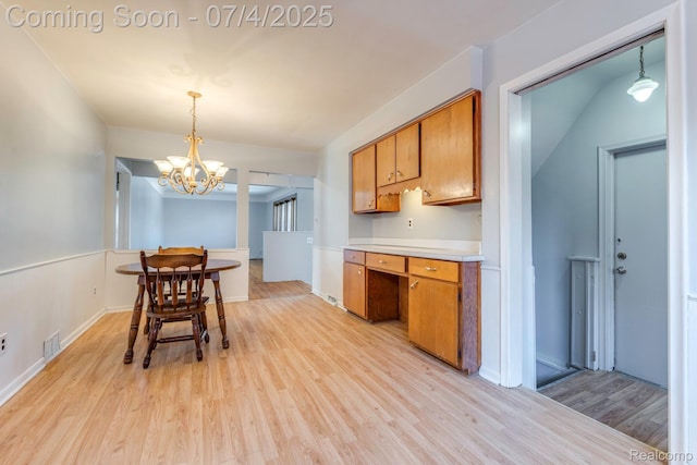 8571 Linda St, Warren, MI 48093 - kitchen with brown cabinets, light wood-style flooring, light countertops, and a chandelier
