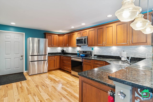 2340 Lakeview Dr, Brooklyn, MI 49230 - kitchen with appliances with stainless steel finishes, brown cabinetry, backsplash, light wood-type flooring, and recessed lighting