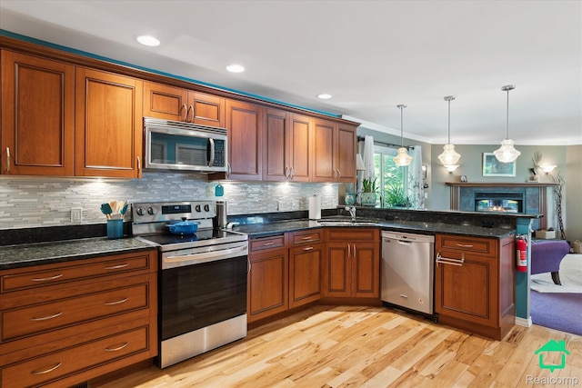 2340 Lakeview Dr, Brooklyn, MI 49230 - kitchen featuring stainless steel appliances, a peninsula, open floor plan, light wood-type flooring, and tasteful backsplash
