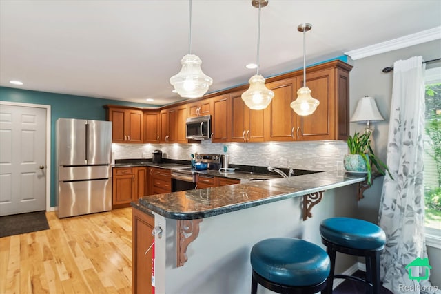 2340 Lakeview Dr, Brooklyn, MI 49230 - kitchen with appliances with stainless steel finishes, brown cabinets, a peninsula, pendant lighting, and recessed lighting