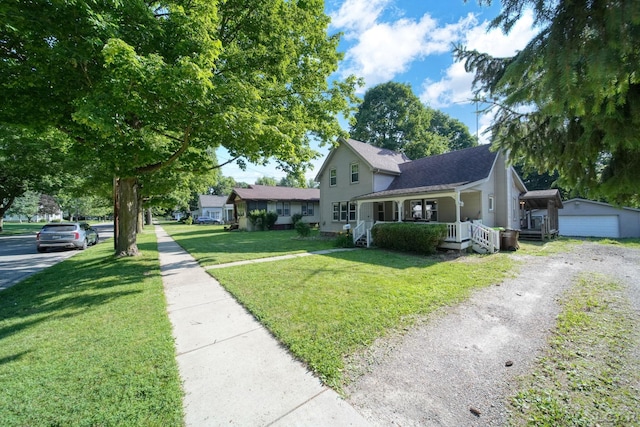 216 Budlong St, Adrian, MI 49221 - view of front of property with covered porch, a front lawn, and an outbuilding