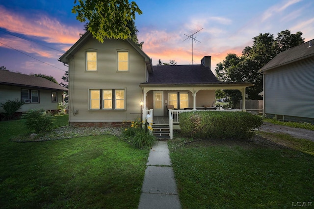 216 Budlong St, Adrian, MI 49221 - traditional-style house featuring a porch, a yard, and a chimney