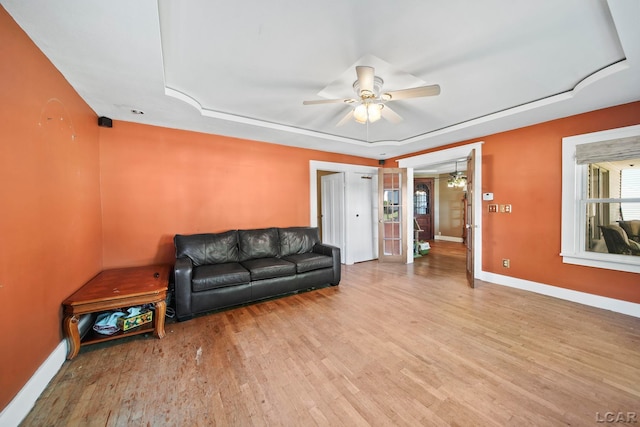 216 Budlong St, Adrian, MI 49221 - living area featuring wood finished floors, plenty of natural light, a ceiling fan, and a tray ceiling