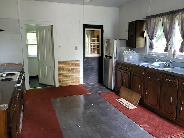233 2nd Ave, Manistee, MI 49660 - kitchen with freestanding refrigerator, dark flooring, white range with electric stovetop, and dark brown cabinetry