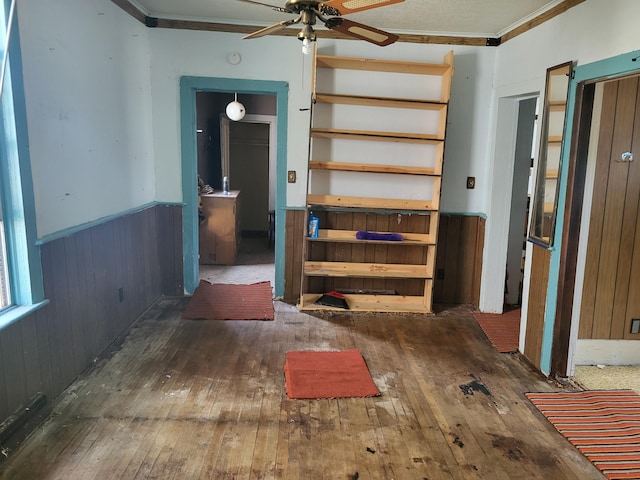 233 2nd Ave, Manistee, MI 49660 - unfurnished room with hardwood / wood-style flooring, a ceiling fan, wainscoting, ornamental molding, and wood walls