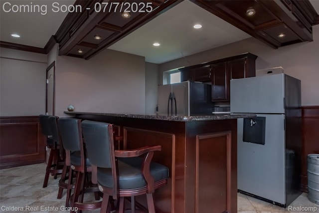 15946 Tubspring Rd, Allenton, MI 48002 - kitchen with freestanding refrigerator, dark stone counters, dark brown cabinetry, a kitchen breakfast bar, and recessed lighting