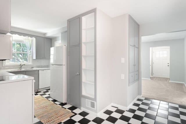 1200 Orchard Ave, Saint Joseph, MI 49085 - kitchen with white appliances, light flooring, gray cabinetry, light carpet, and light countertops
