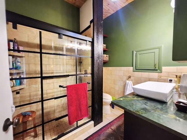241 Dale St, Grayling, MI 49738 - bathroom with tile walls, a shower stall, vanity, tile patterned flooring, and a wainscoted wall