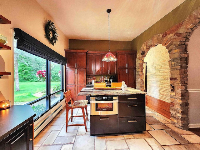 241 Dale St, Grayling, MI 49738 - kitchen with a baseboard radiator, stainless steel oven, decorative light fixtures, and light countertops