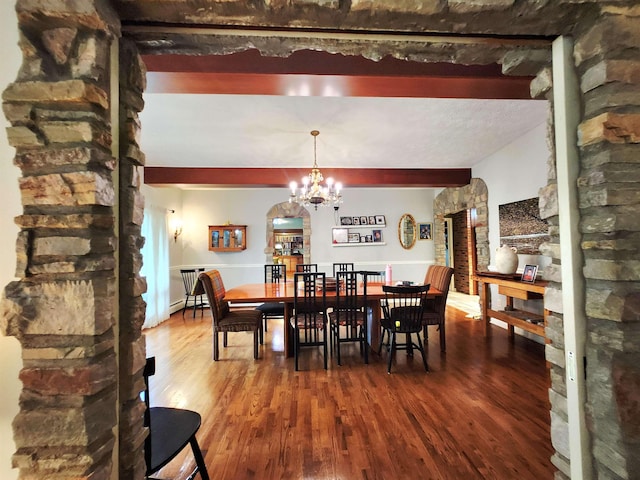 241 Dale St, Grayling, MI 49738 - dining area with wood finished floors, arched walkways, a chandelier, and beam ceiling