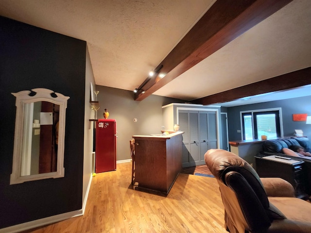 241 Dale St, Grayling, MI 49738 - bar area with light wood-style flooring, beam ceiling, track lighting, and a textured ceiling