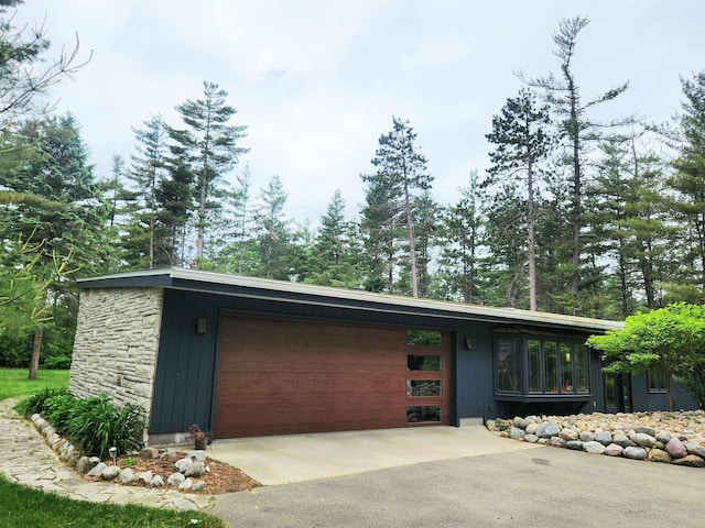 241 Dale St, Grayling, MI 49738 - view of front of home with a garage, driveway, and stone siding