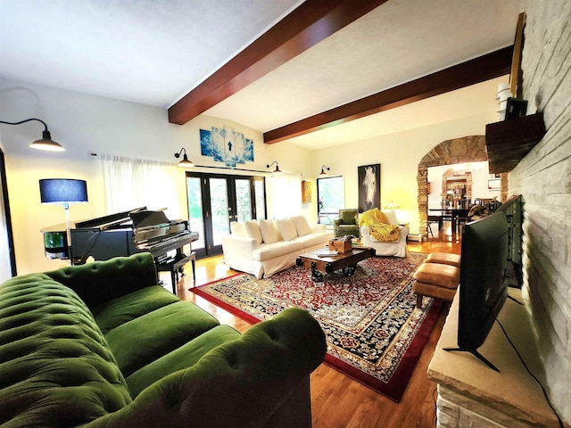 241 Dale St, Grayling, MI 49738 - living room featuring wood finished floors, beam ceiling, arched walkways, and french doors