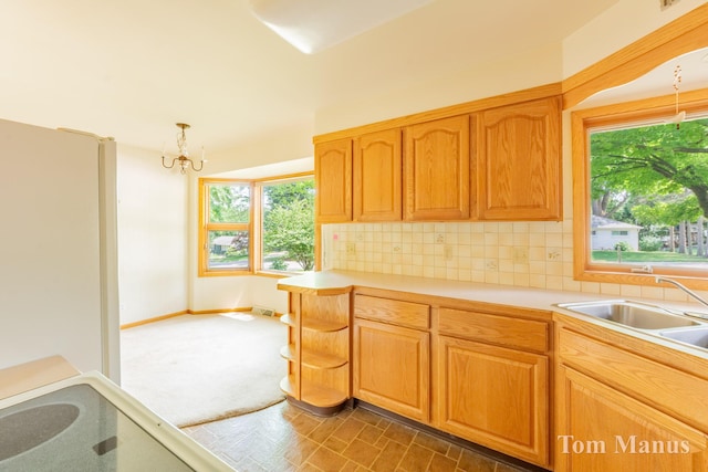 7131 Windcrest St SE, Grand Rapids, MI 49546 - kitchen with a chandelier, decorative backsplash, light countertops, and pendant lighting