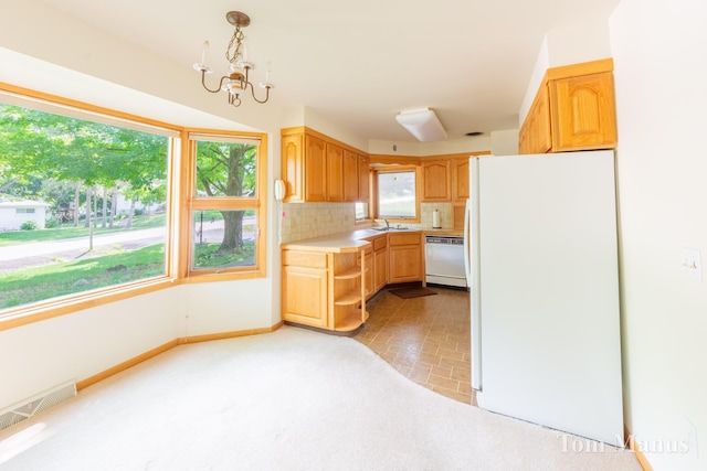 7131 Windcrest St SE, Grand Rapids, MI 49546 - kitchen with white appliances, light countertops, decorative backsplash, a chandelier, and light colored carpet