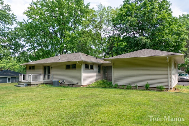 7131 Windcrest St SE, Grand Rapids, MI 49546 - rear view of house with a wooden deck, a lawn, and roof with shingles