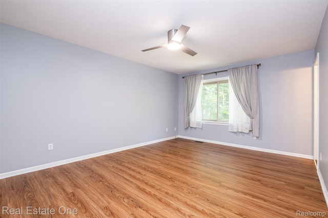 4079 Cumberland Ct, Commerce Twp, MI 48390 - empty room with a ceiling fan and wood finished floors