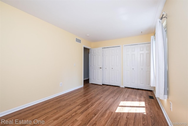 4079 Cumberland Ct, Commerce Twp, MI 48390 - unfurnished bedroom with wood finished floors and multiple closets