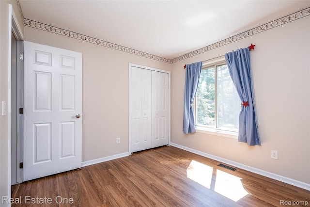4079 Cumberland Ct, Commerce Twp, MI 48390 - unfurnished bedroom featuring wood finished floors and a closet
