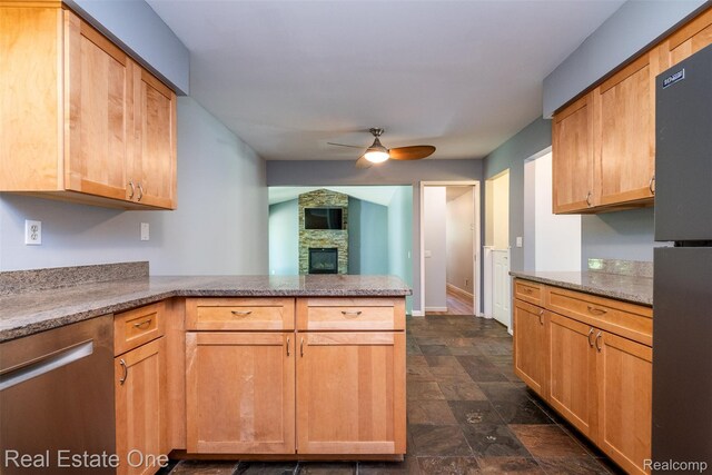 4079 Cumberland Ct, Commerce Twp, MI 48390 - kitchen featuring dishwasher, a peninsula, freestanding refrigerator, a ceiling fan, and a fireplace