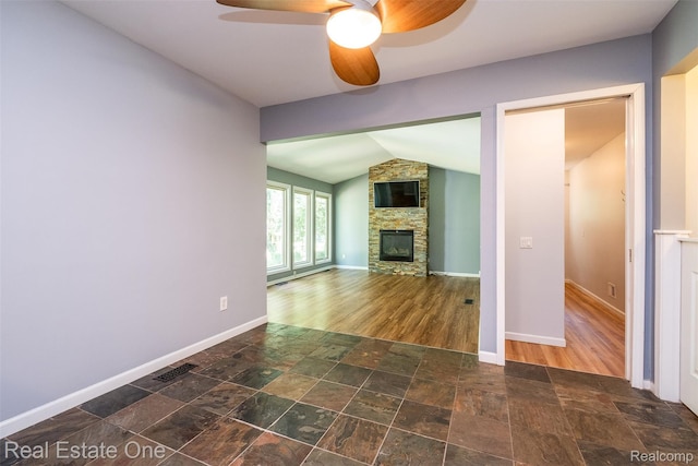 4079 Cumberland Ct, Commerce Twp, MI 48390 - unfurnished living room featuring vaulted ceiling, ceiling fan, a fireplace, and stone finish floors